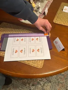 Cutting a sheet of free printable Thanksgiving place cards with a paper trimmer on the dining table